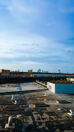 A skilled roofer inspecting a flat roof under a bright New York City sky near W 40th St.