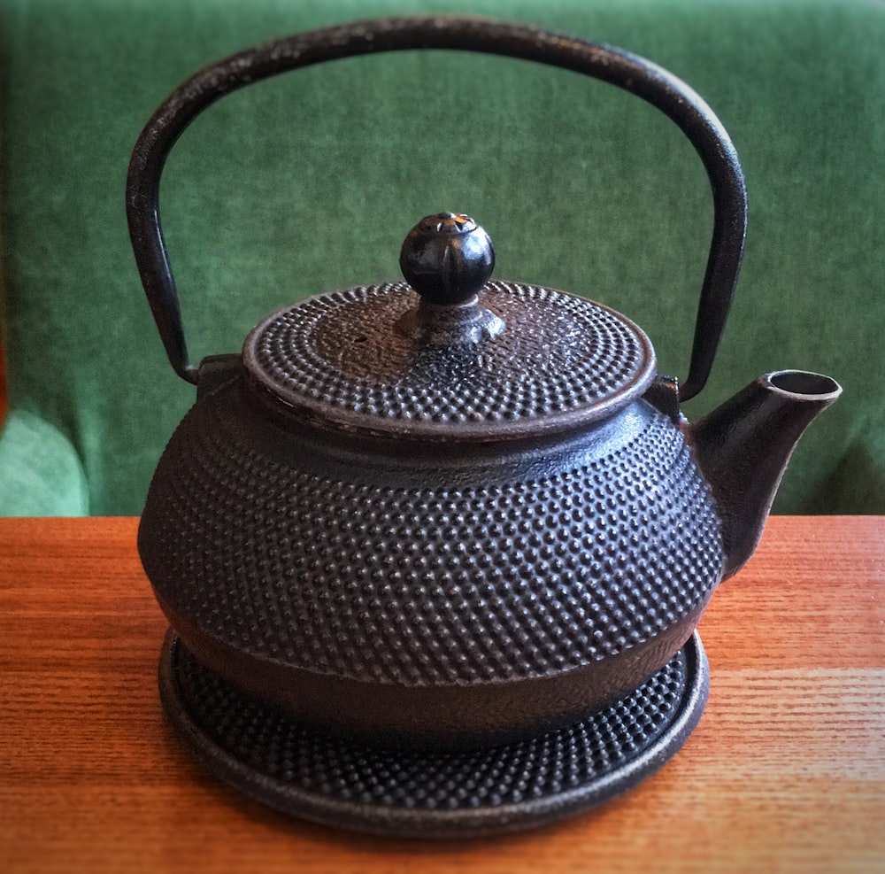 black teapot on wooden surface