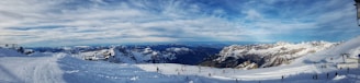 A scenic view of snow-covered mountains with skiers.