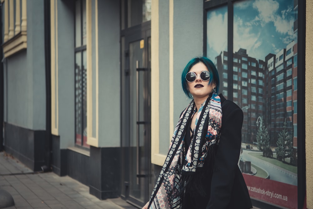 shallow focus photo of woman in black coat wearing round sunglasses