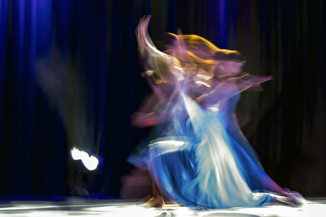 a couple of people that are dancing on a stage, Dance performance on indoors on the theatre stage.