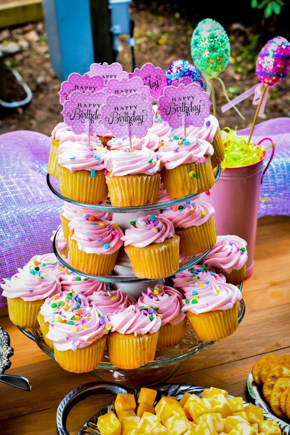 a table topped with lots of cupcakes covered in pink frosting