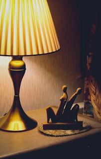 Warmly lit handcrafted lamp casting intricate shadows on a cozy wooden table