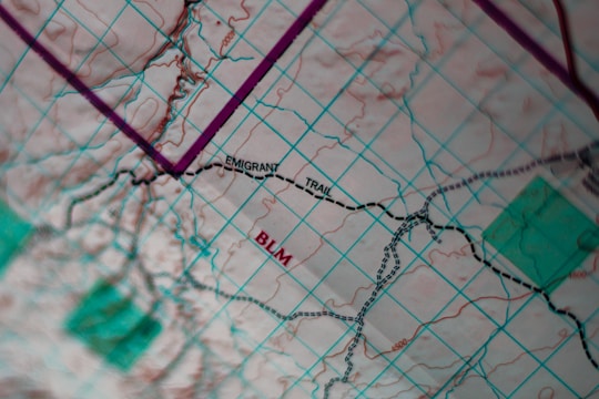 A close-up view of a topographical map featuring a grid overlay. The map highlights the 'Emigrant Trail' and 'BLM' in bold text. There are marked trails with dashed lines and various geographical features such as contours and elevations.