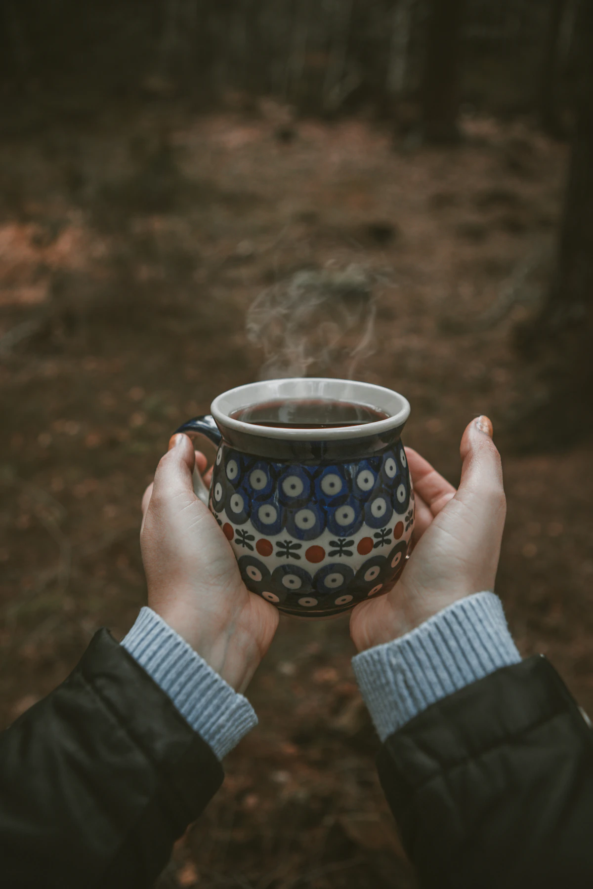 Hände halten eine warme Tasse als Symbol für eine einfache Ersatzhandlung ohne Zigarette