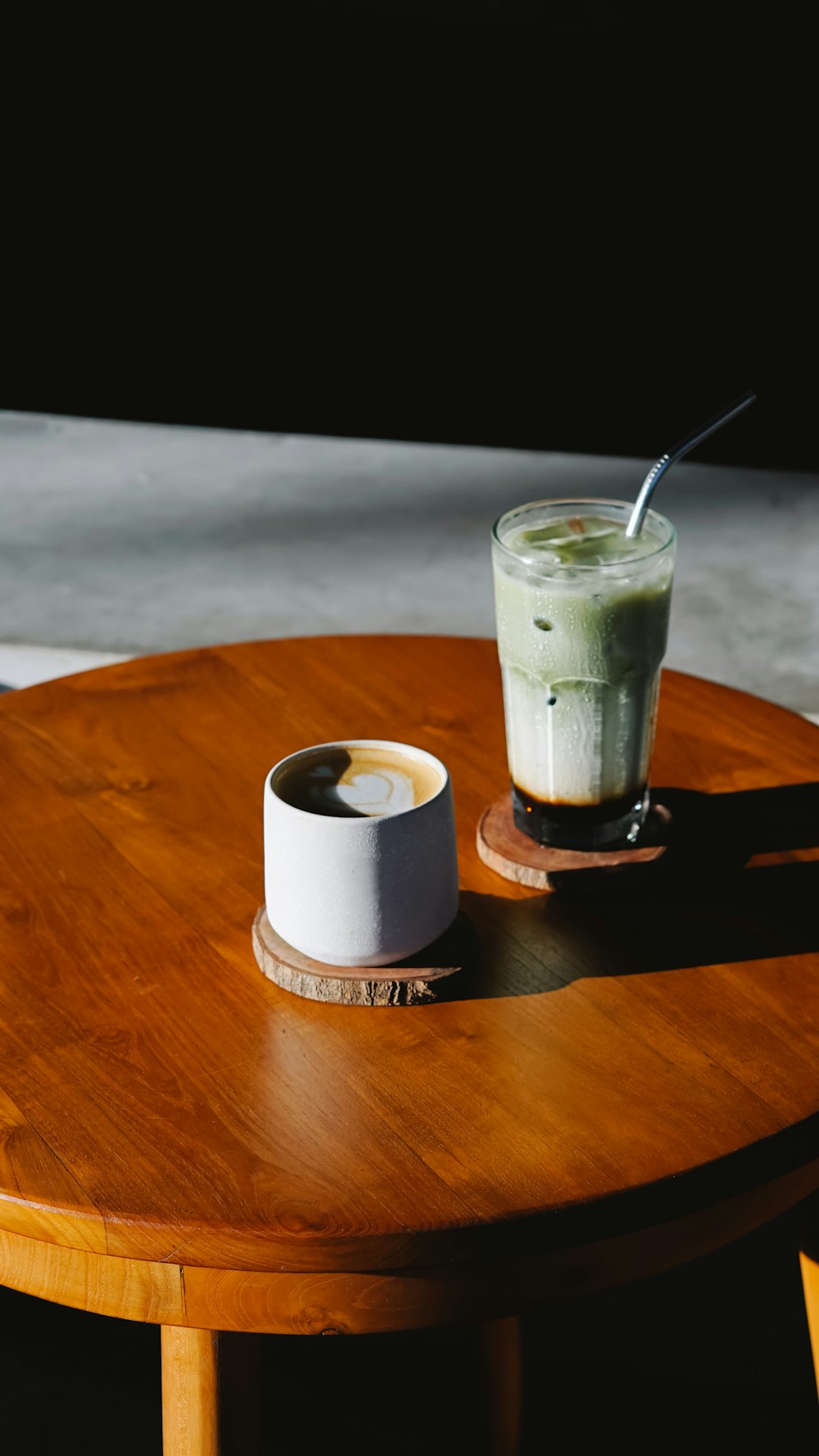 cup beside glass cup on table