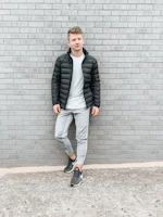 A model wearing a trendy, comfortable jacket standing against a minimalist urban backdrop