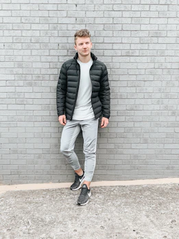 Model wearing a sleek black t-shirt with a minimalist streetwear vibe against an urban backdrop.