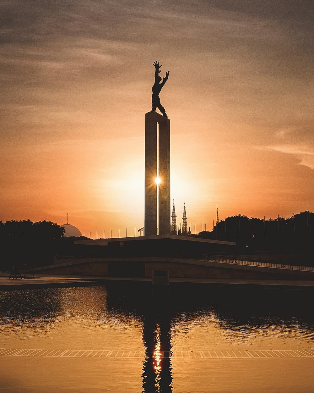 a statue of a person standing on top of a tall tower