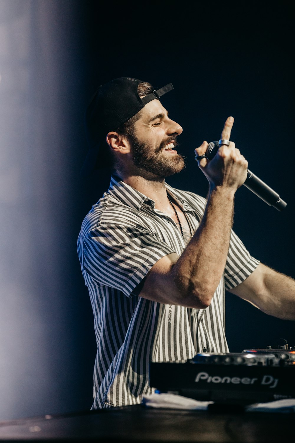 man in gray and black shirt holding microphone