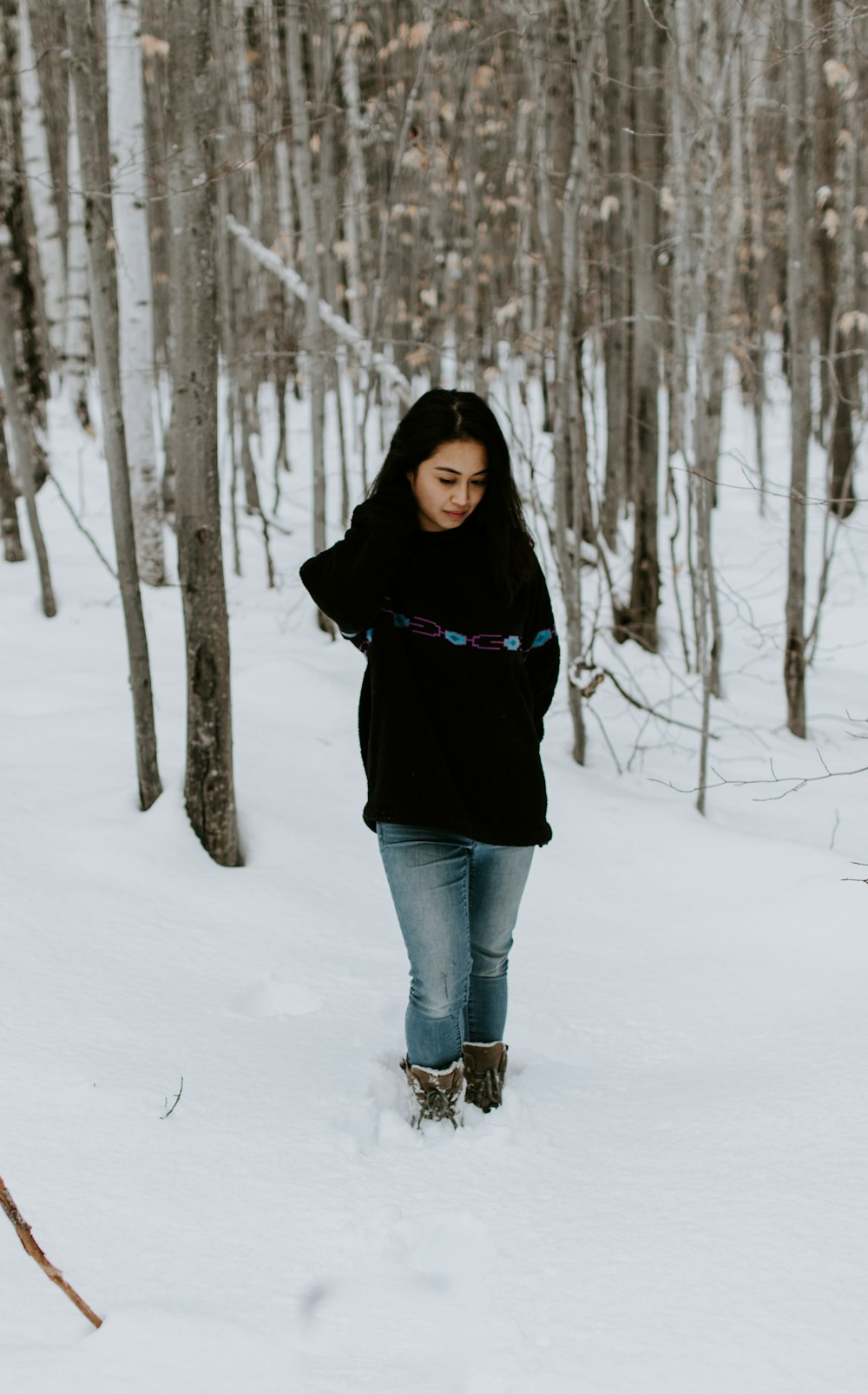 Frau im schwarzen Hemd steht auf Schnee