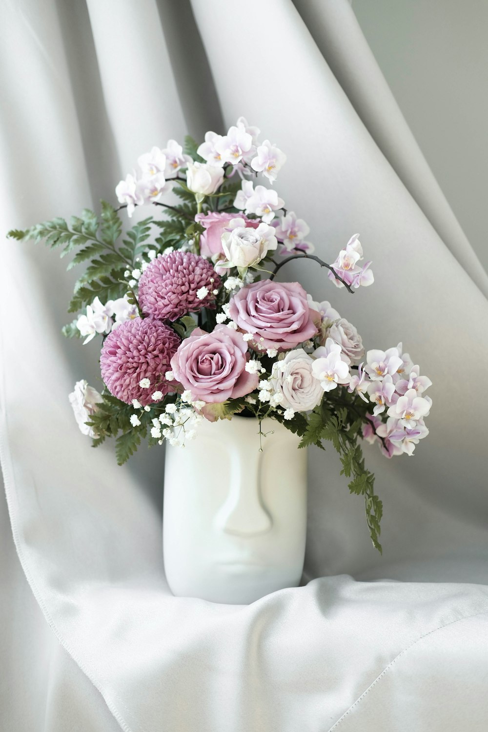 Jarrón de flor de pétalos rosas y blancos