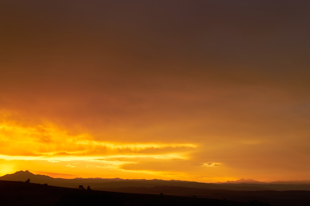 silhouette of mountains under cloudy sky