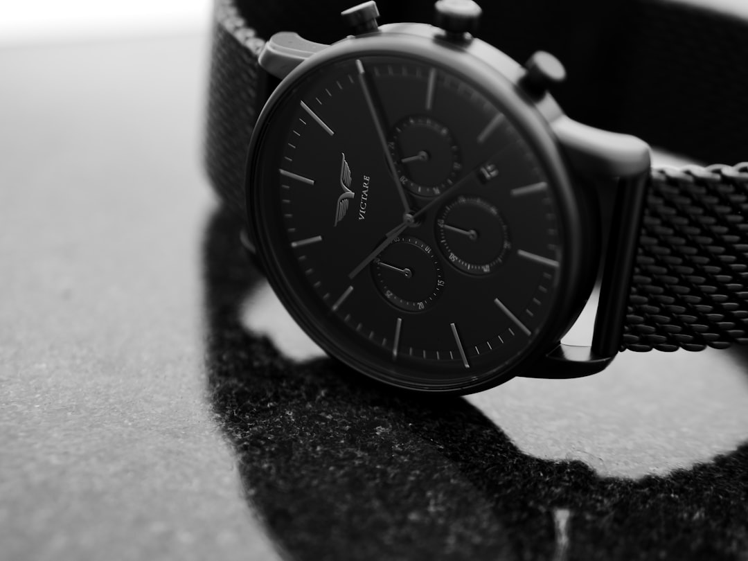 shallow focus photo of round black chronograph watch