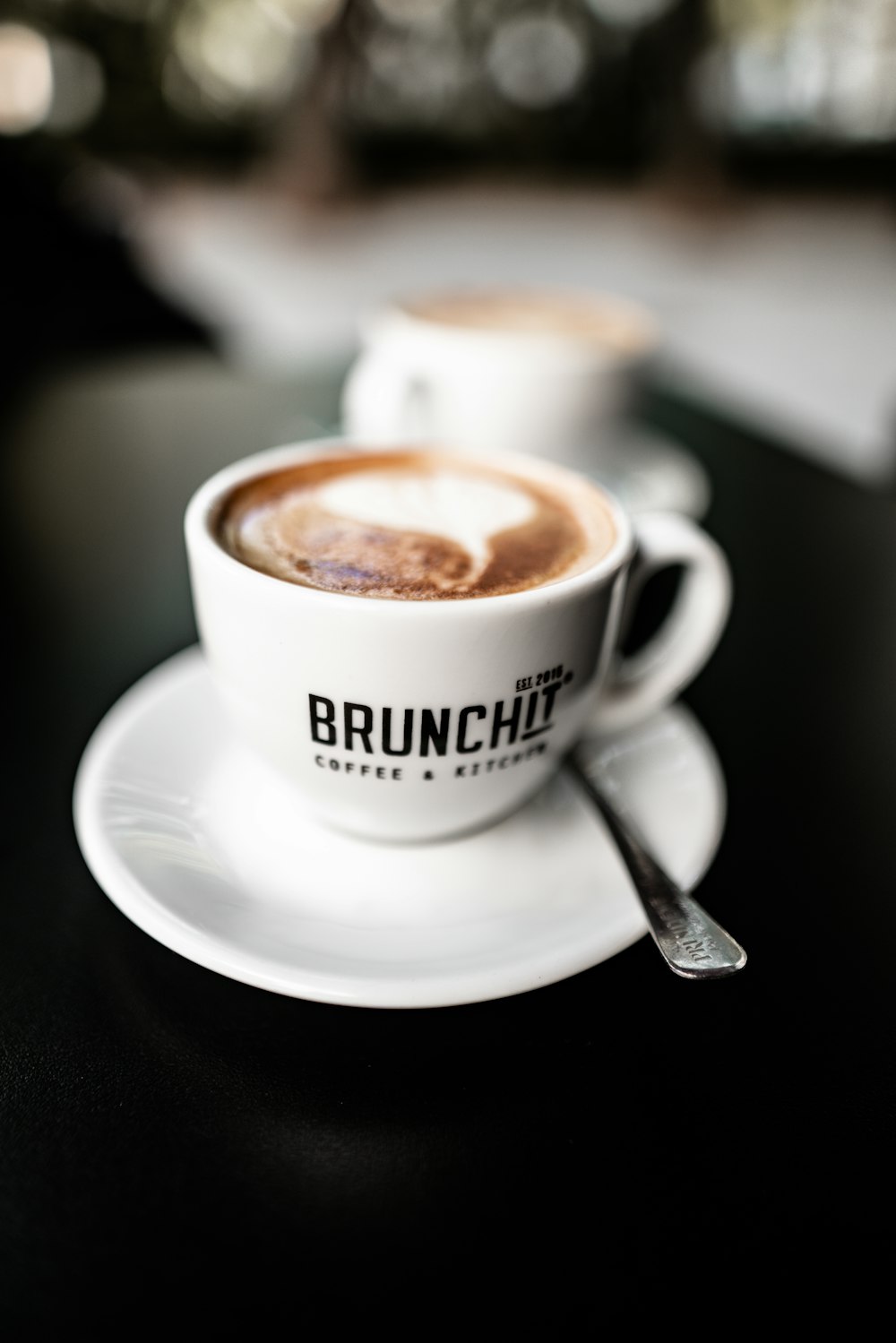 shallow focus photo of latte in white ceramic mug