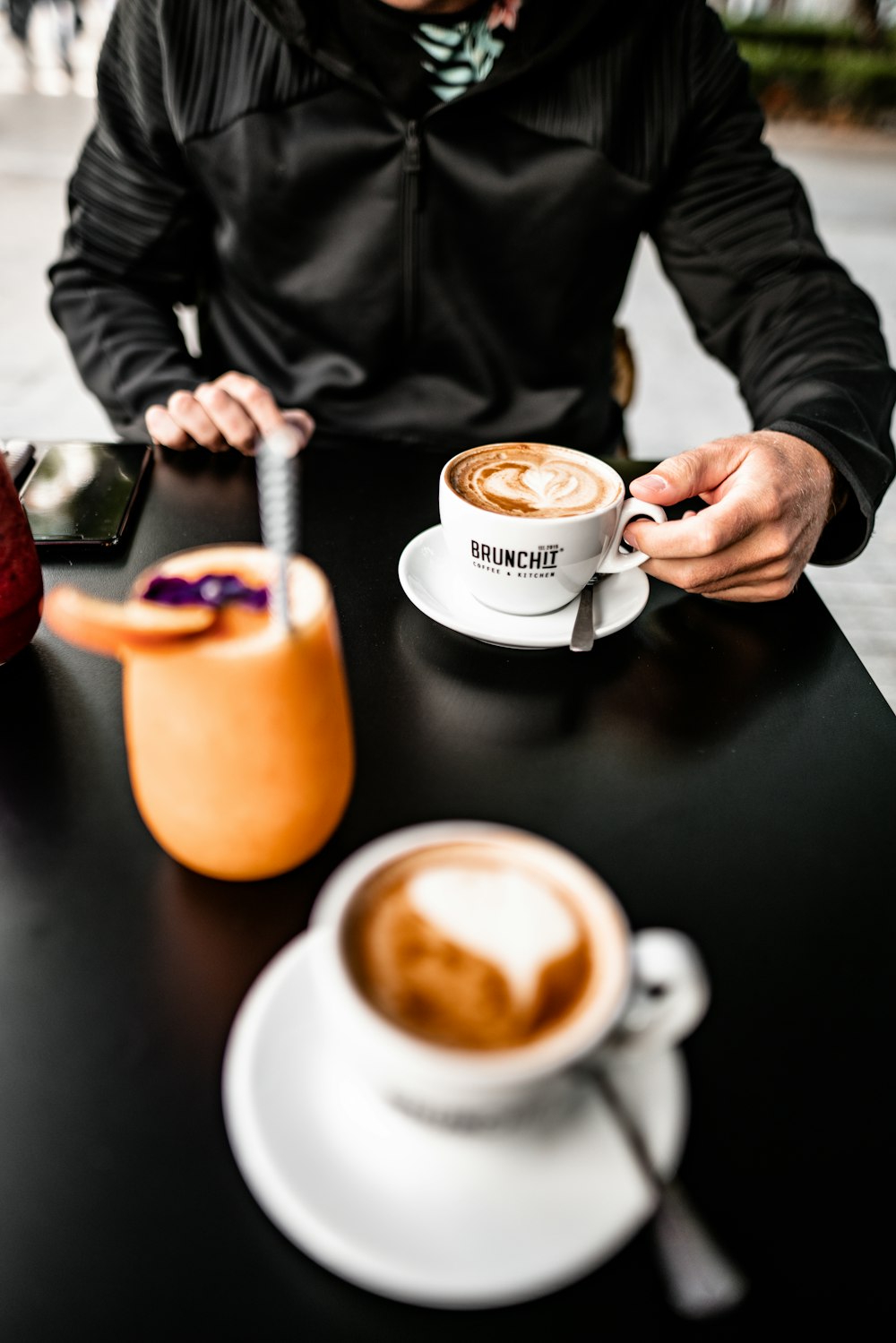 shallow focus photo of person holding white ceramic mug