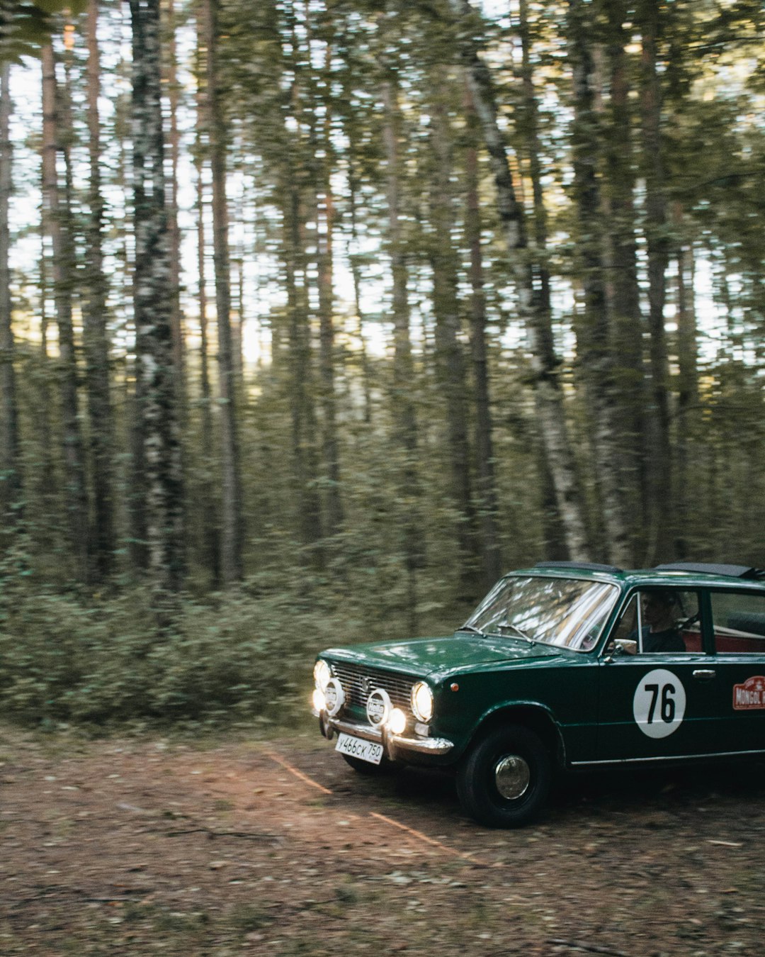 green sedan near trees