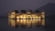 The calm waters of Gaurishankar Lake reflecting palace and temple lights in perfect harmony.