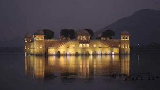 The calm waters of Gaurishankar Lake reflecting palace and temple lights in perfect harmony.