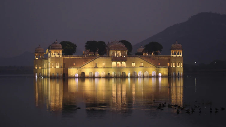 Evening view of Moti Mahal restaurant overlooking the calm waters of Lake Pichola with warm, inviting lights.