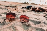 Close-up of vibrant sunglasses resting on a beach towel.