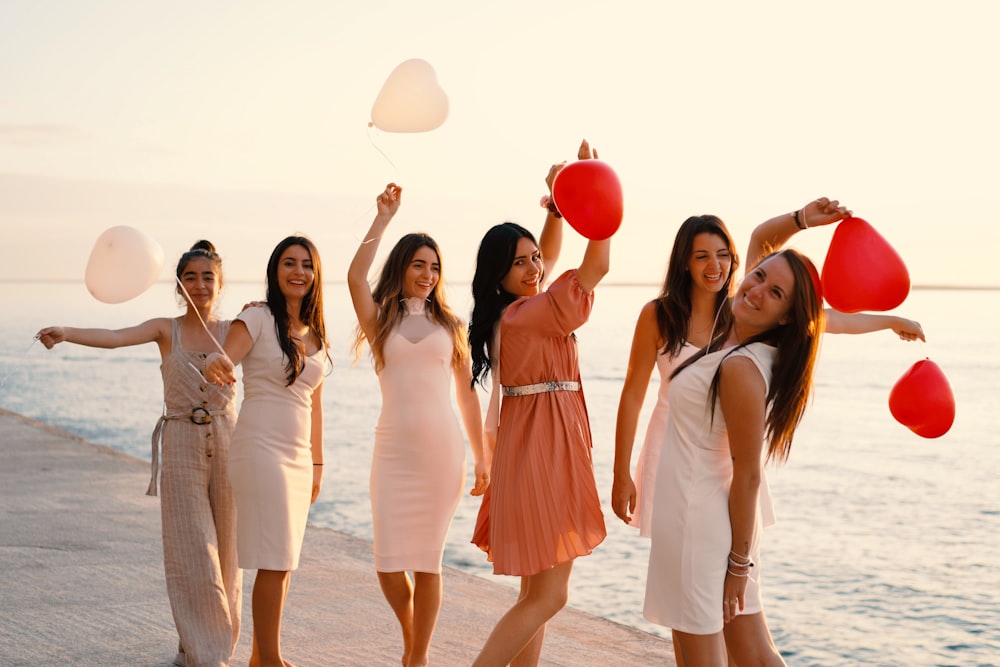 group of women standing near body of water