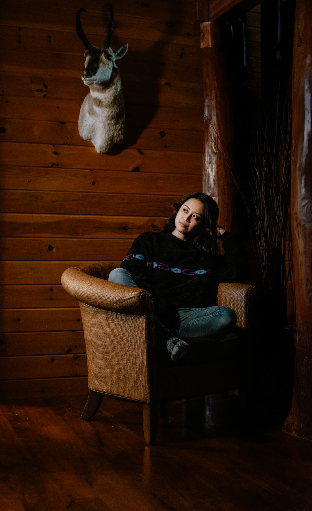 woman sitting on brown leather Chesterfield sofa chair