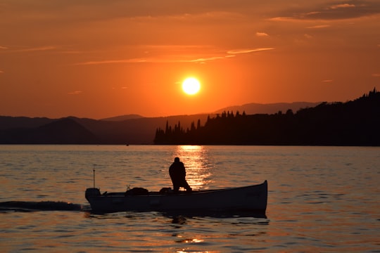 silhouette photography unknown person riding on boat in Garda Italy