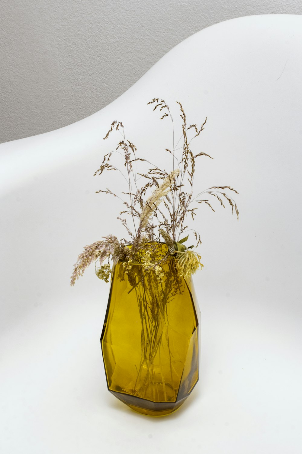 grasses in yellow translucent glass vase