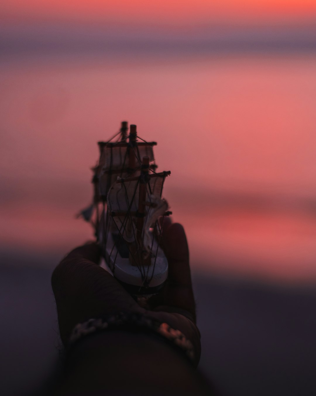 person holding a white and brown ship miniature