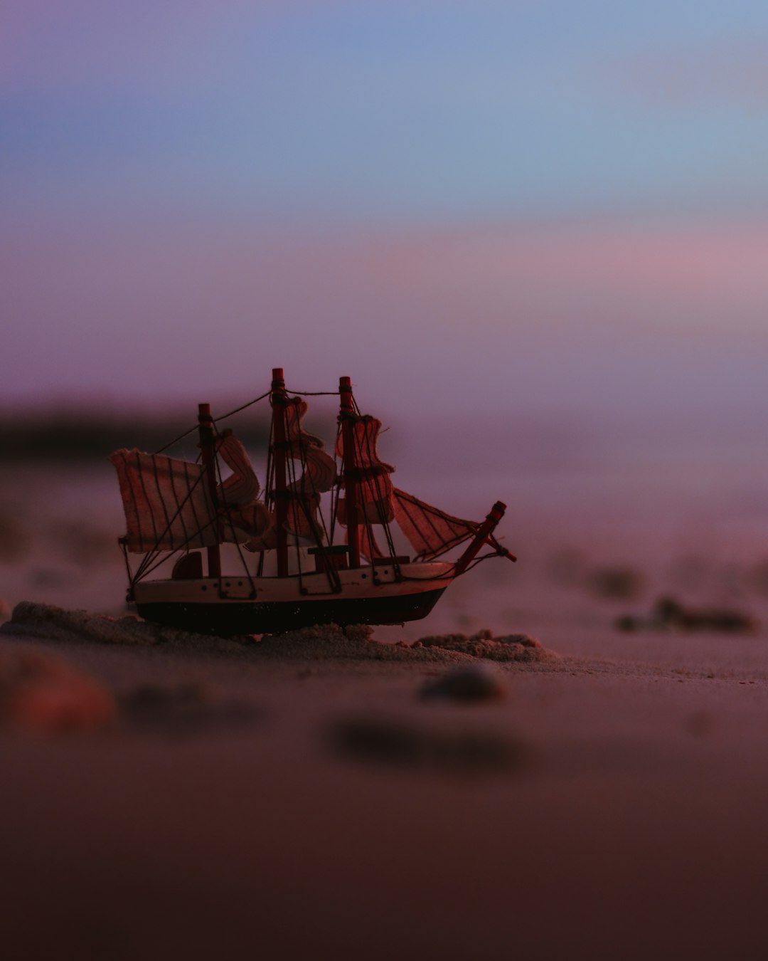 brown and white ship miniature by the seashore