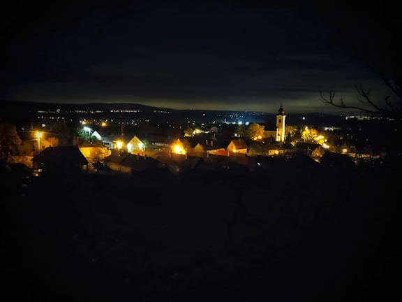 Evening view of a peaceful village street with warm lights glowing