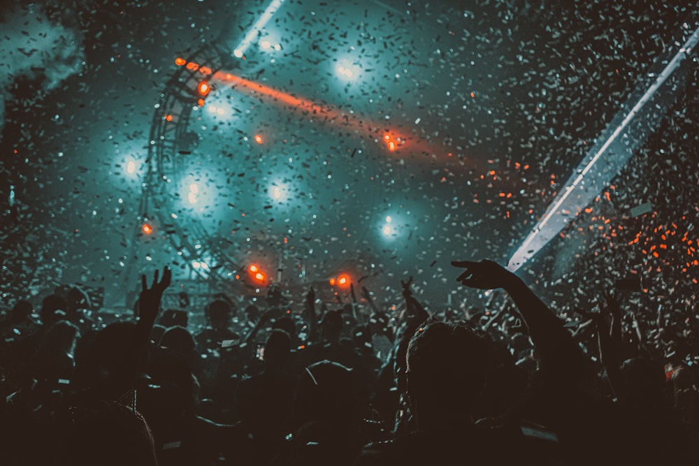 Multitud festejando con luces rojas en el escenario