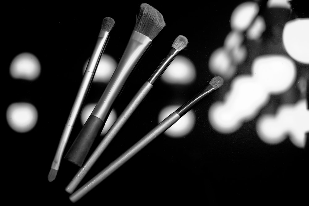 grayscale photo of makeup brushes