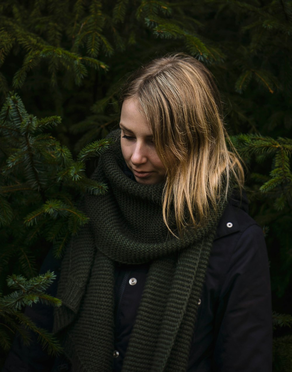 woman standing near pine trees