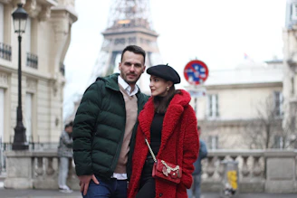 Fashionable man and woman walking in the streets of Paris showcasing trendy clothing and accessories.