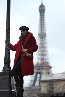 A sunlit street in Paris with a woman wearing a chic trench coat and ankle boots.