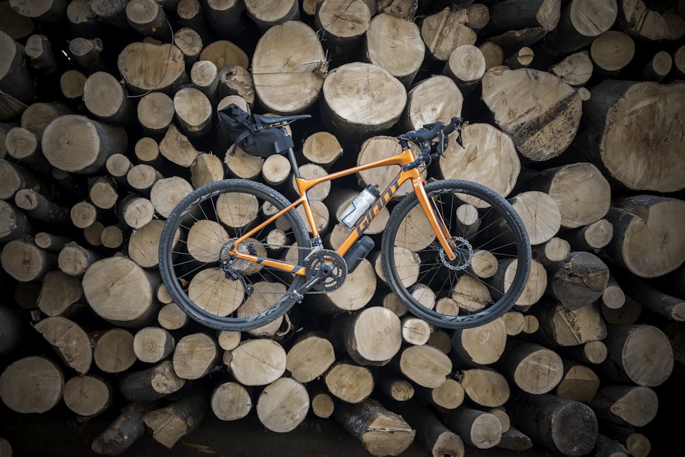 orange and black road bike on brown logs