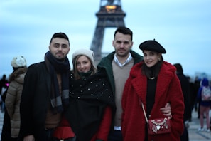 A group photo of the communithink team smiling in front of their Paris office, with the Eiffel Tower faintly in the background.