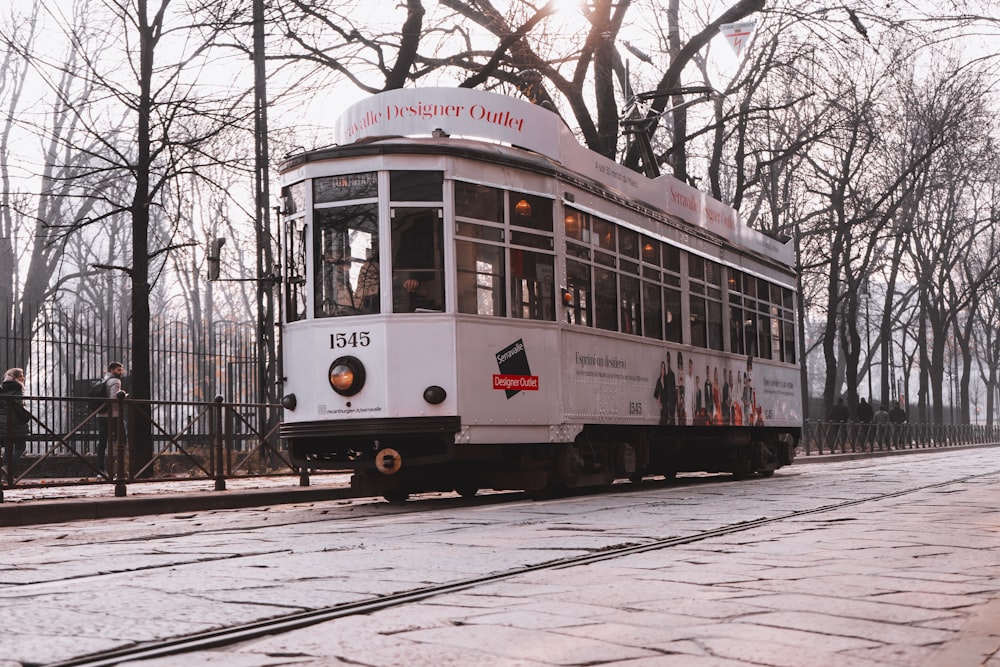 white tram crossing beside bare trees