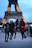 Happy group of friends posing in front of the Eiffel Tower in Paris