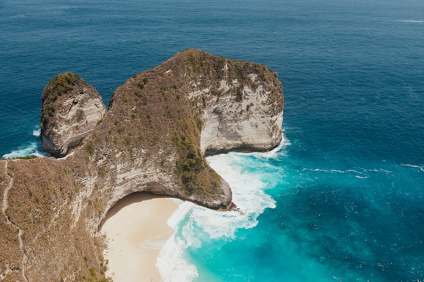 A stunning view of Kelingking Beach with turquoise waters and dramatic cliffs.