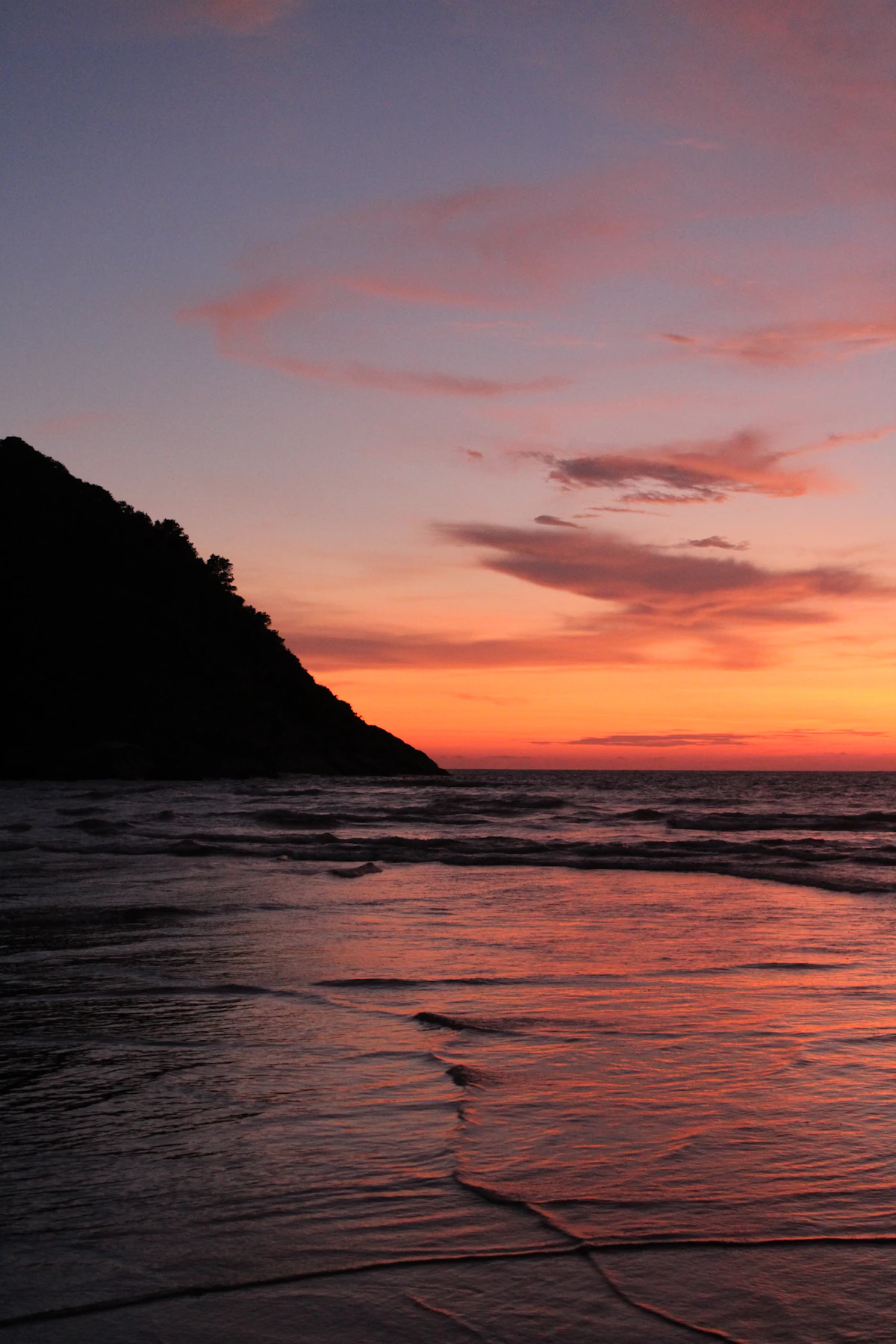 Golden sand cove, rocky headlands and Arabian Sea sunset at Kudle Beach, Gokarna