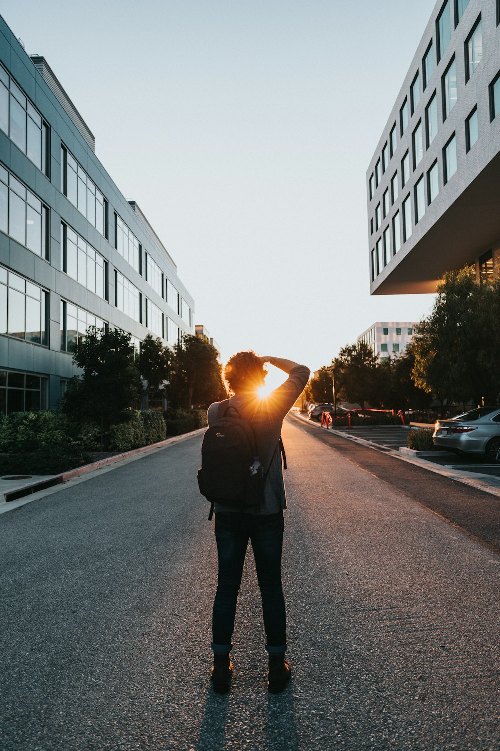 person standing in the middle of the road during golden hour