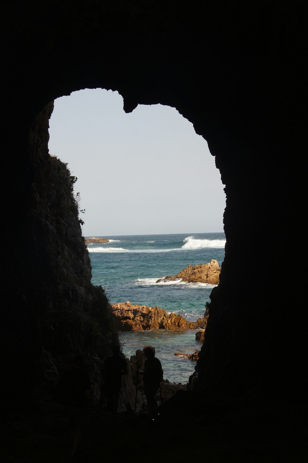 two person standing in cave