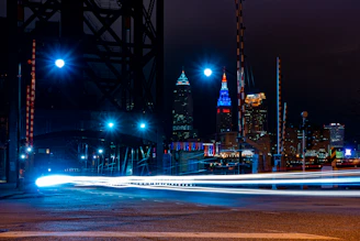 A city skyline at night with red streaks of light symbolizing fast-moving news.