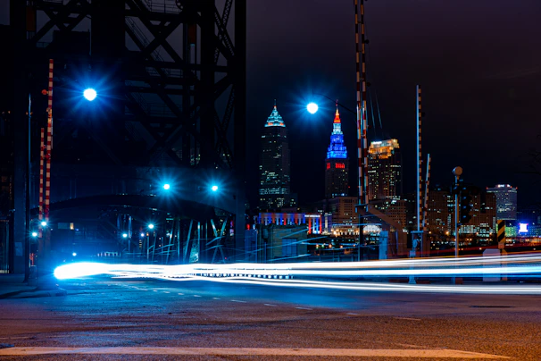 A city skyline at night with red streaks of light symbolizing fast-moving news.