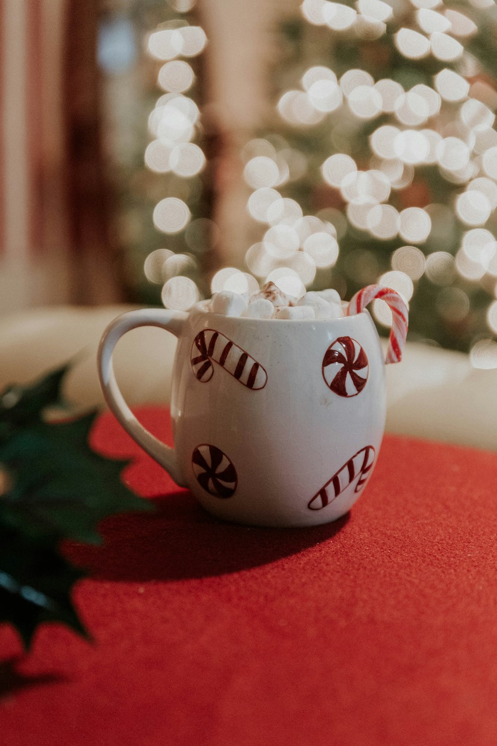 a mug with a candy cane in it sitting on a table