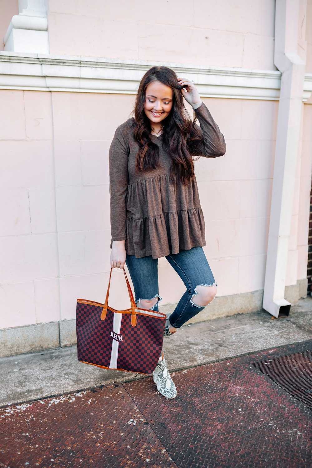 smiling woman standing against wall