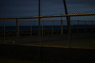 Evening shot of a fenced area with gentle lighting highlighting the clean finishing and level ground